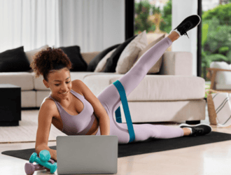 Person following a fitness workout on a streaming screen at home